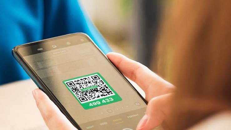 A phone camera scanning the green QR label on a shipping carton